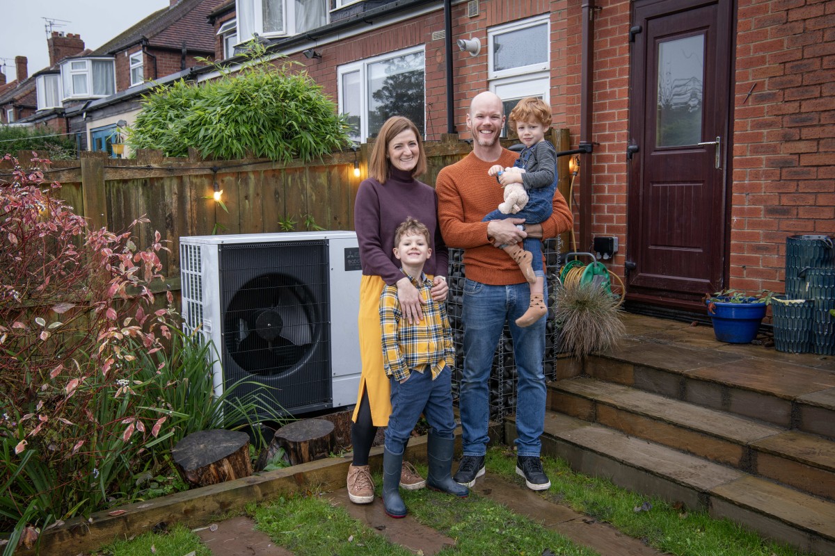 The Rennison-Rae family, adopters of green energy stand next to their heat source pump
